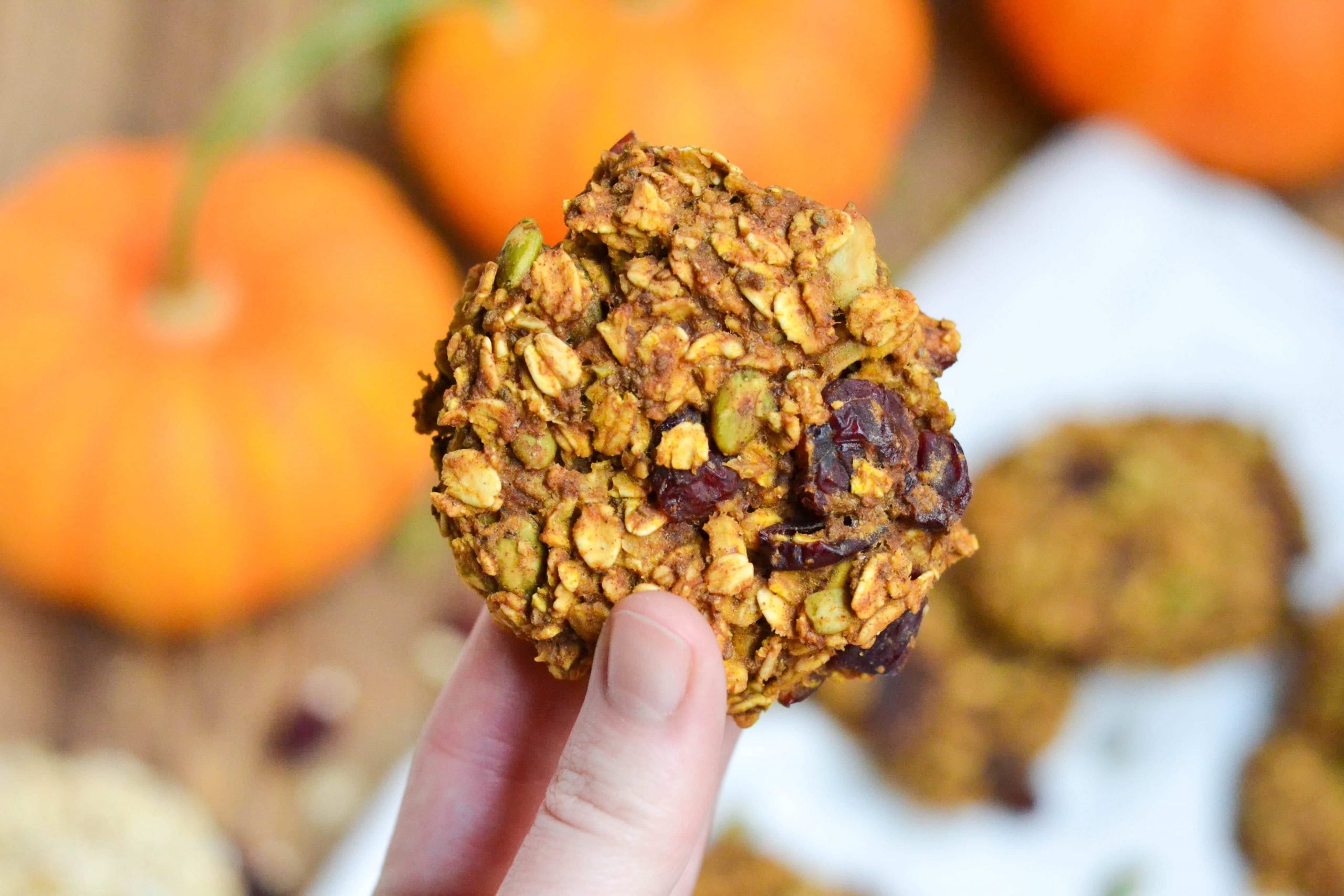 A hand holding a pumpkin breakfast cookie. 