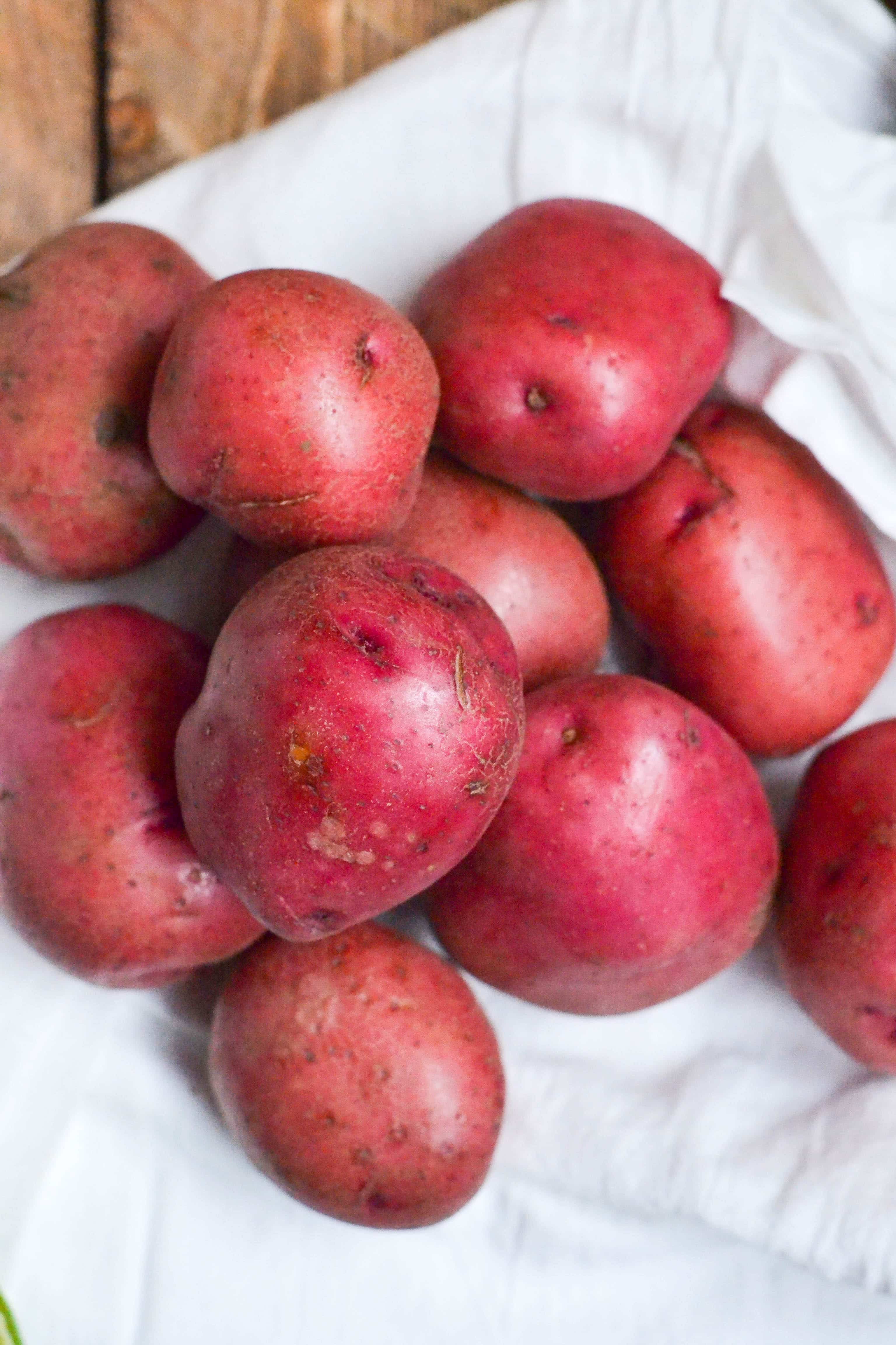 A stack of red potatoes on a white linen napkin. 