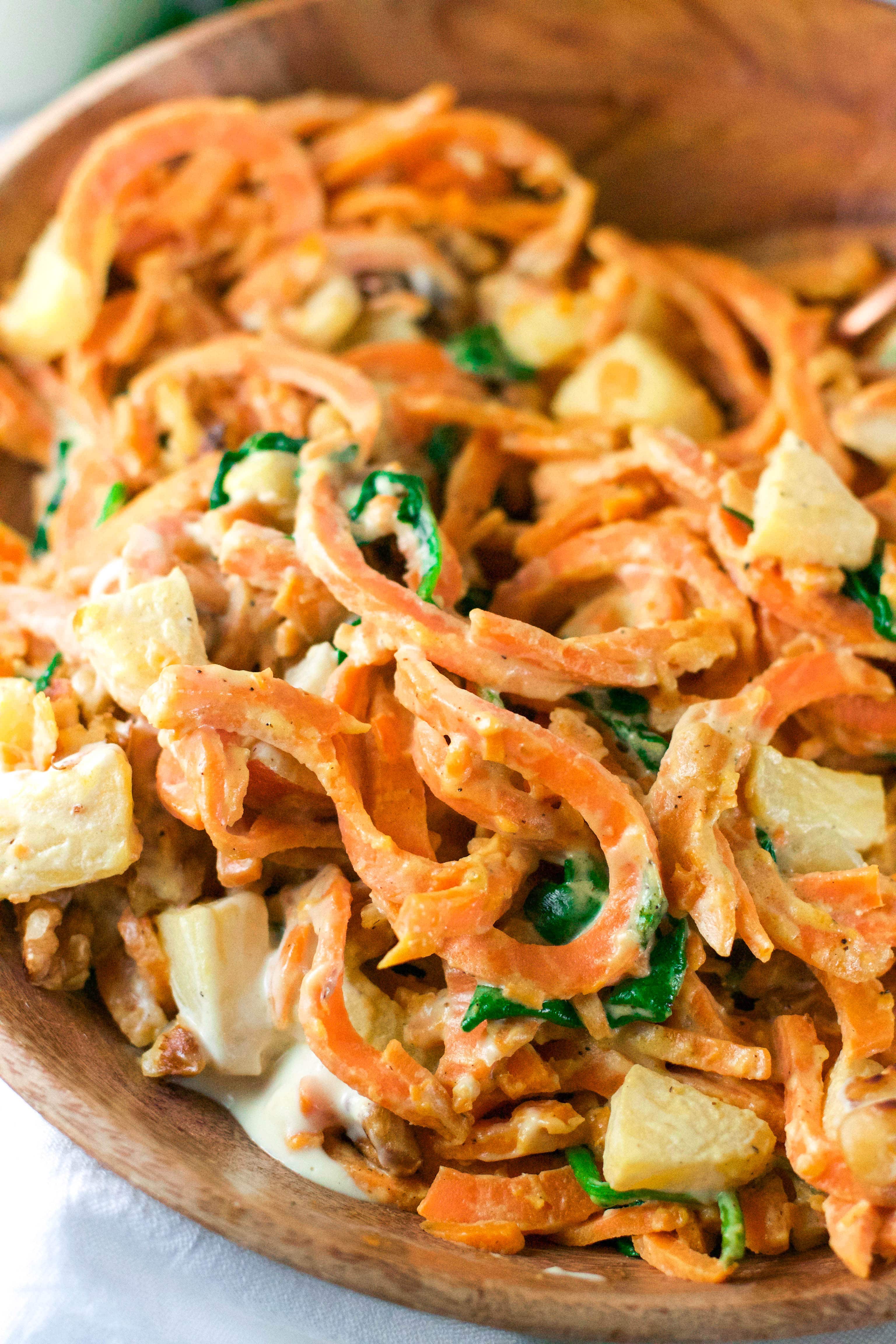 A closeup of sweet potato noodles covered in cashew sauce and topped with apples. 