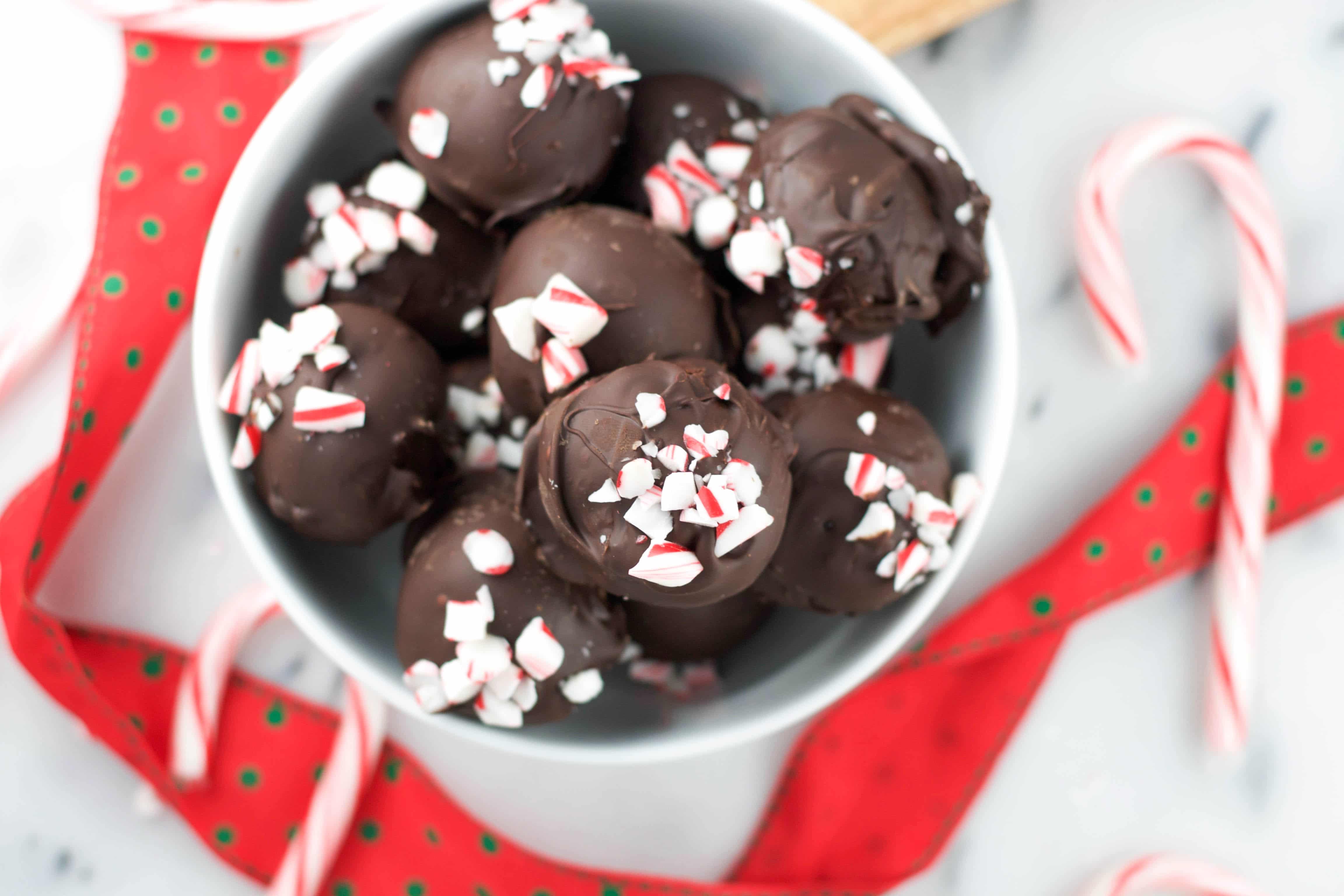 A bowl of Vegan Peppermint Chocolate Truffles with crushed candy canes on top of them. 