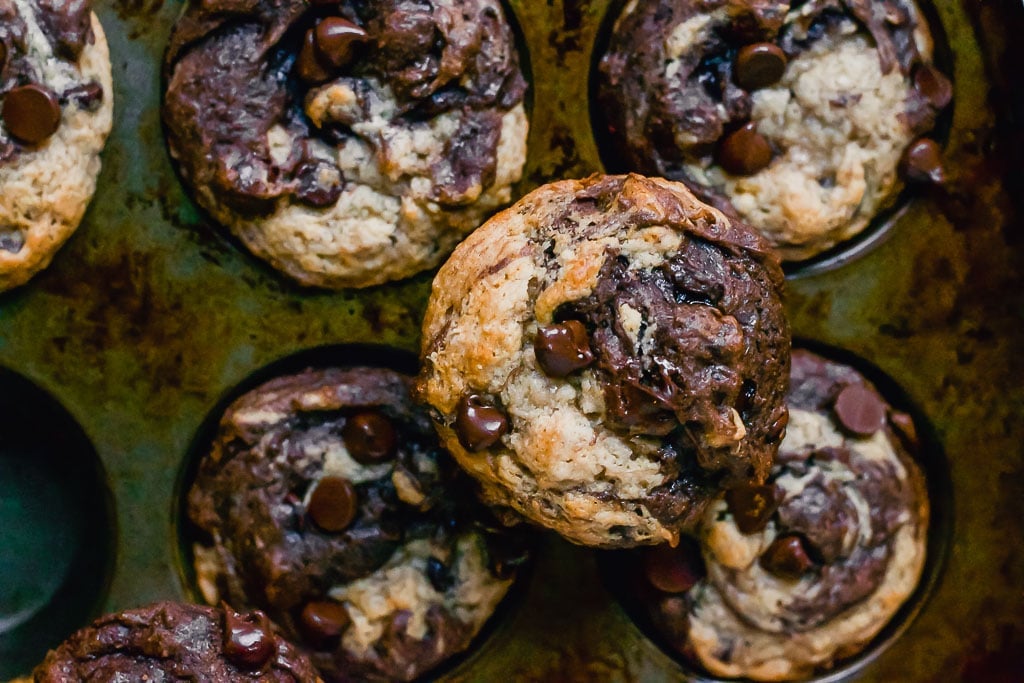 chocolate peanut butter banana with a swirl and studded with dark chocolate chips muffin in a muffin tin - gluten-free, vegan, dairy-free swirl muffin