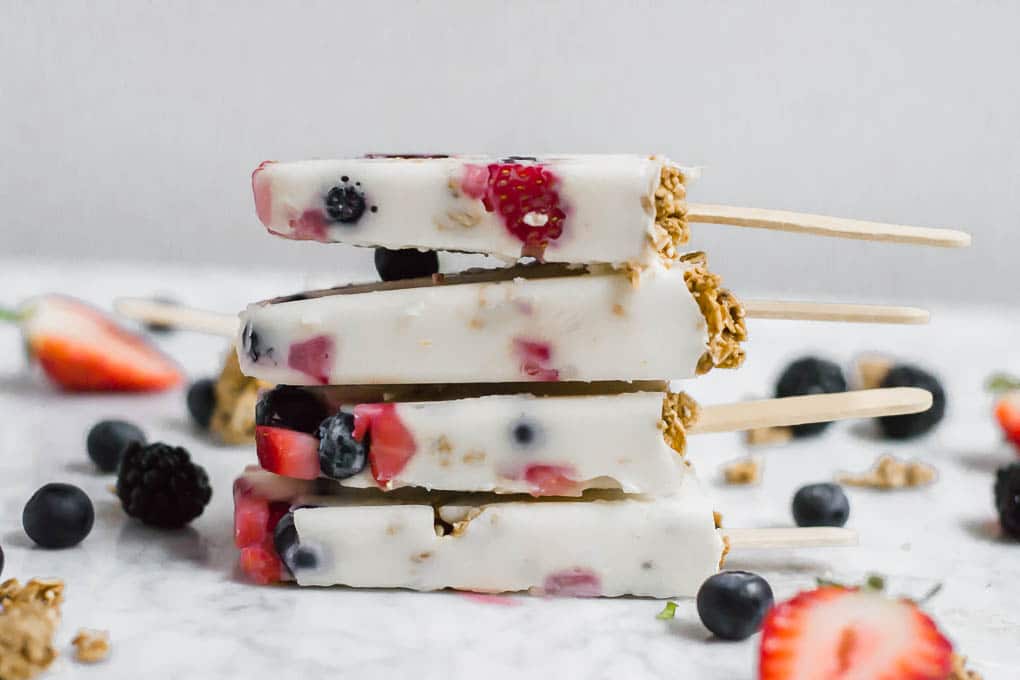 Front view of a stack of four gluten-free yogurt and granola breakfast popsicles.