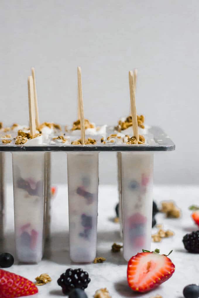 Front view of yogurt and granola breakfast popsicles in the popsicle mold ready for freezing.