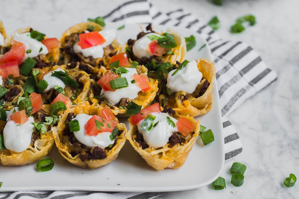 A plate of gluten-free mini beef taco bites on a marble table.