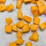 A sheet of parchment paper with polenta croutons and a spoon.