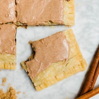 A giant pop tart with brown sugar cinnamon filling and cinnamon glaze with a bite out of a slice.