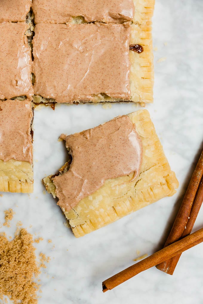 A giant pop tart with brown sugar cinnamon filling and cinnamon glaze with a bite out of a slice. 
