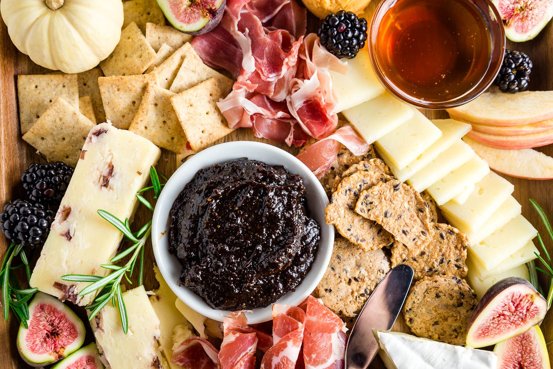 Orange fig jam with cheeses, meats and gluten-free crackers for a fall harvest charcuterie and cheese board