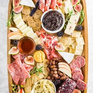 A fall inspired charcuterie board with various cheese, meats, dips, nuts and crackers.