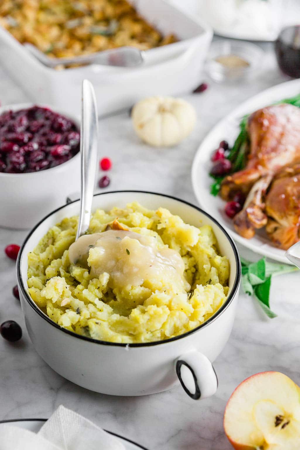 A gluten-free thanksgiving table with roasted garlic mashed potatoes, turkey, stuffing and cranberry sauce.