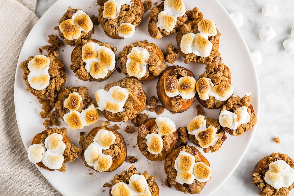 A plate of brown sugar crumble gluten-free sweet potato casserole bites with toasted marshmallows on top. 