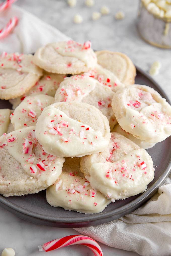 A plate of gluten-free white chocolate peppermint cookies with crushed candy canes on top. 