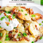 A photo of a plate of Irish Nachos with potatoes, cheddar cheese, bacon, sour cream and green onions.