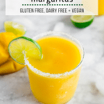 A photo of a frozen mango margarita with a salt rim and lime wedge.