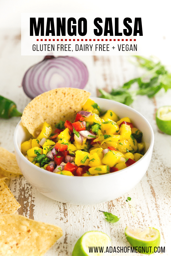 A photo of a bowl of jalapeÃ±o mango salsa with a tortilla chip in it. 