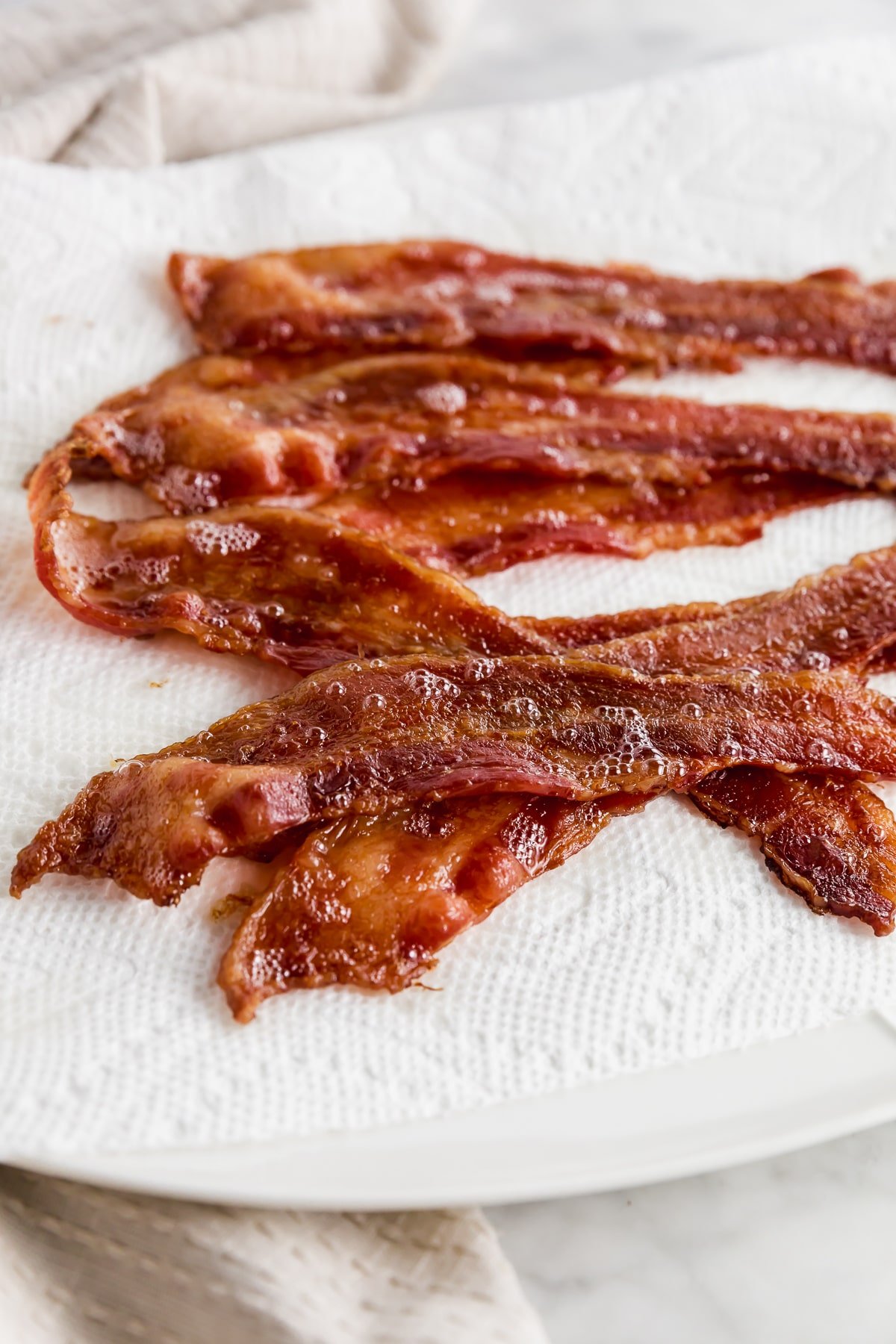 Baked bacon straight from the oven on a plate.