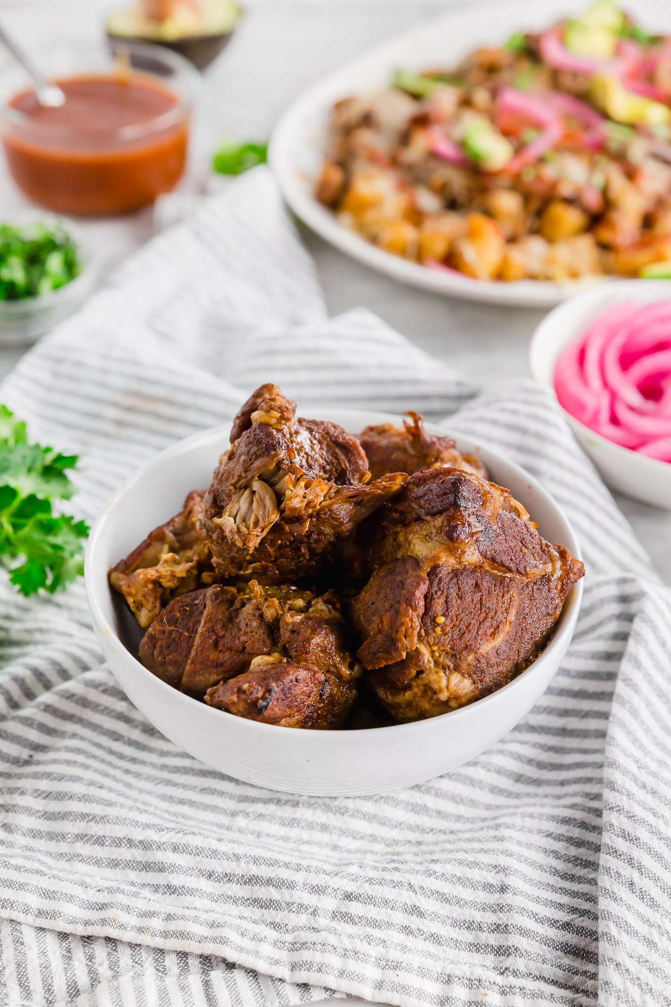 A bowl of Instant Pot BBQ Pulled Pork ready to be put on top of crispy tater tots. 