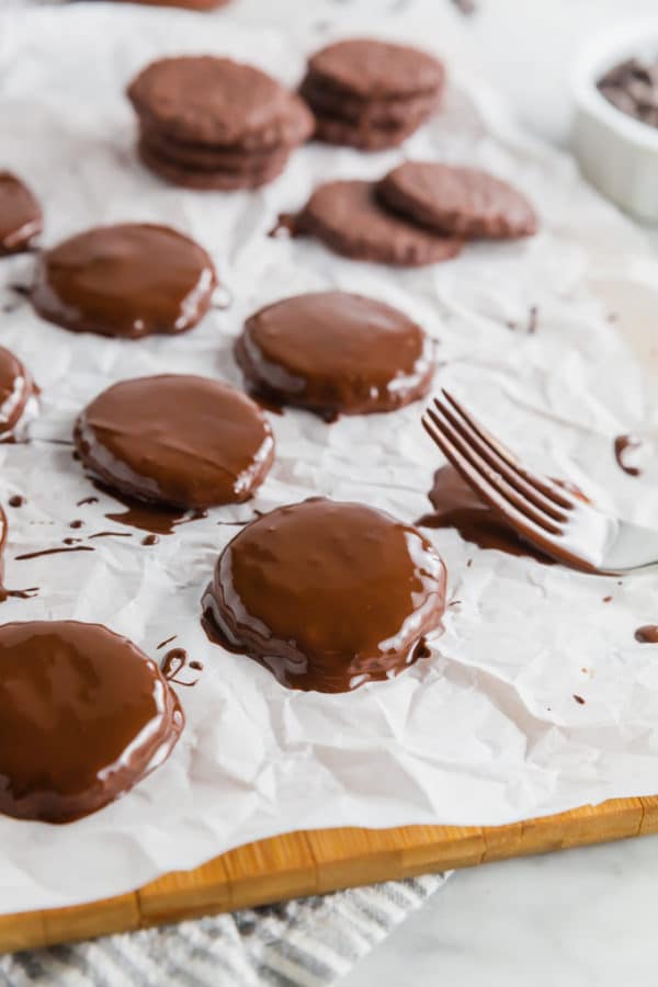 Chocolate thin mint cookies on parchment paper after being dipped in melted chocolate chips and waiting to try. 