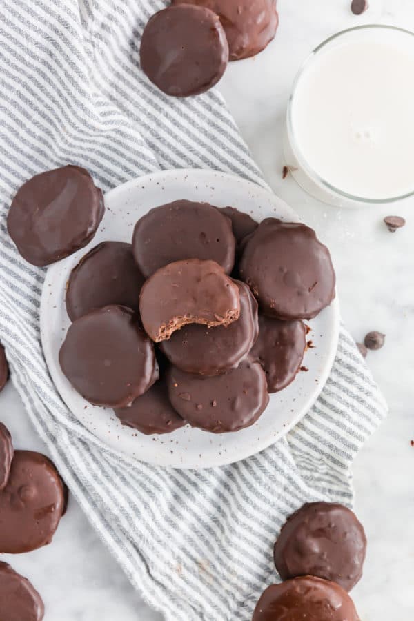A plate of gluten-free chocolate mint cookies with a glass of milk. 