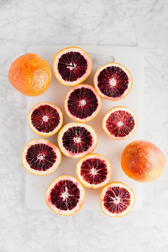 An aerial view of blood orange sliced open on a cutting board.