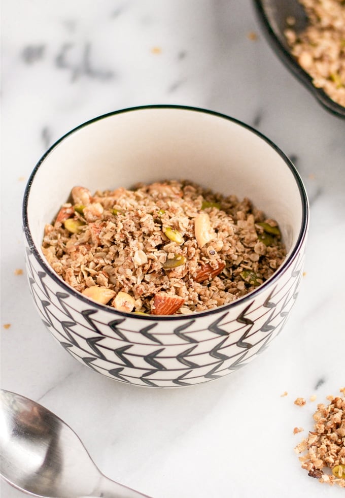 A bowl of granola with pumpkin seeds and almonds.