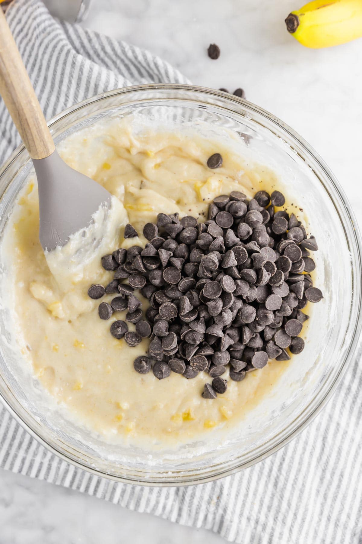 A bowl of banana muffin batter with chocolate chips added in.