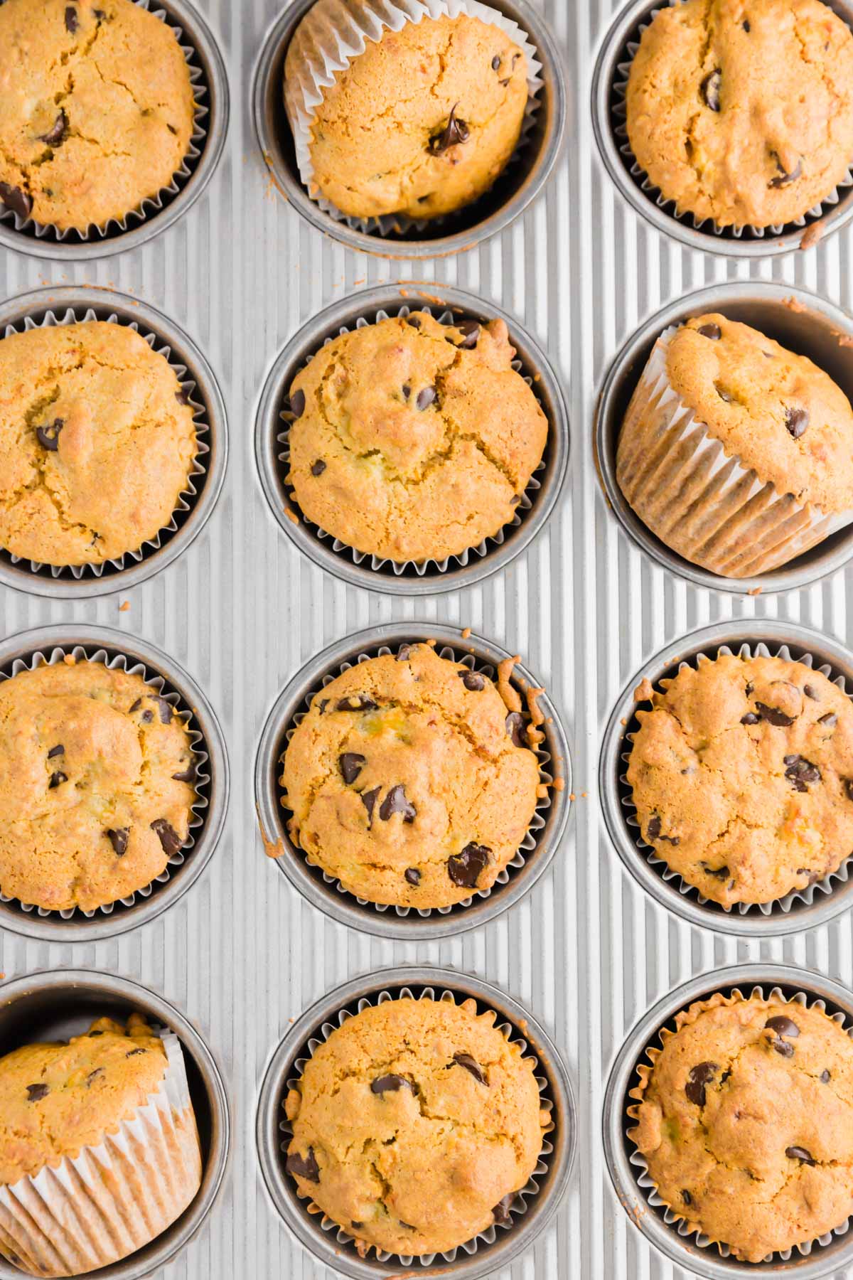 An overhead shot of a muffin tin holding 12 gluten-free vegan banana chocolate chip muffins.