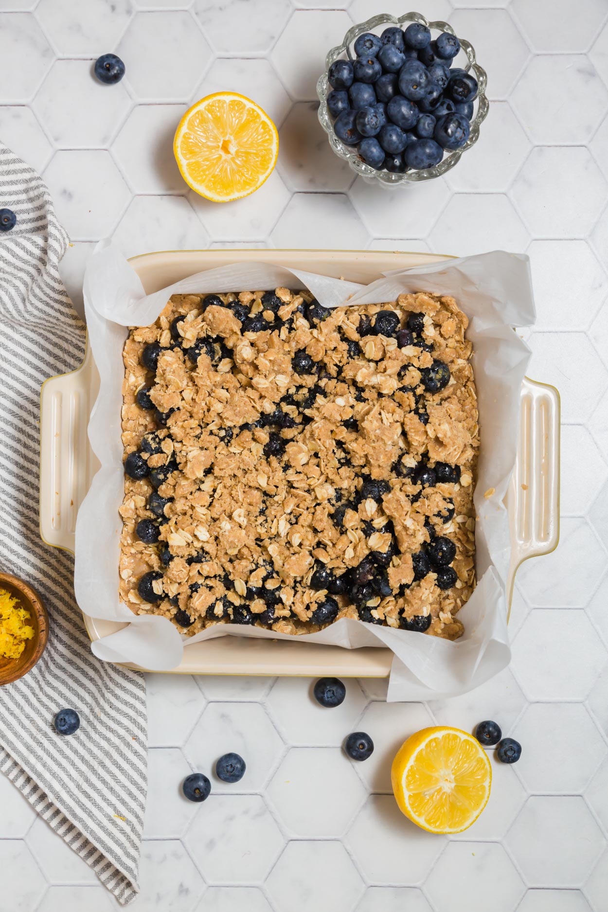 An overhead photo of gluten-free crumb topping over blueberry filling for blueberry crumb bars. 