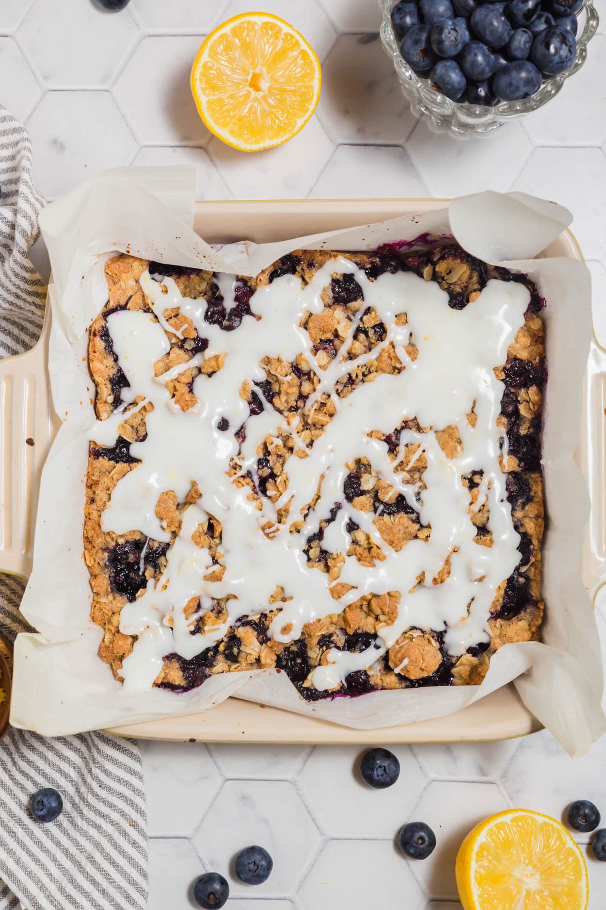 An overhead photo of blueberry crumb bars with fresh lemon glaze drizzled over it.