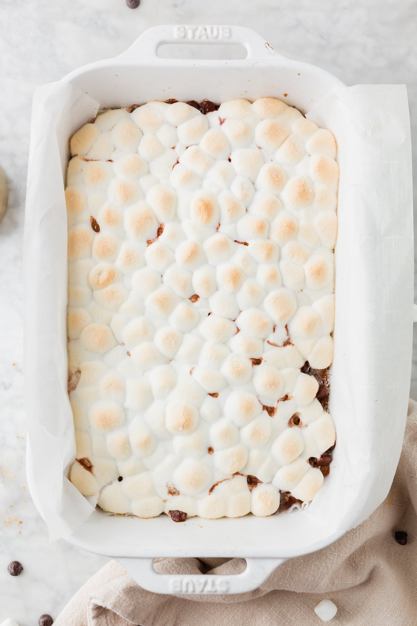 A baking dish with graham crackers, mini marshmallows and chocolate chips that just came out of the oven.