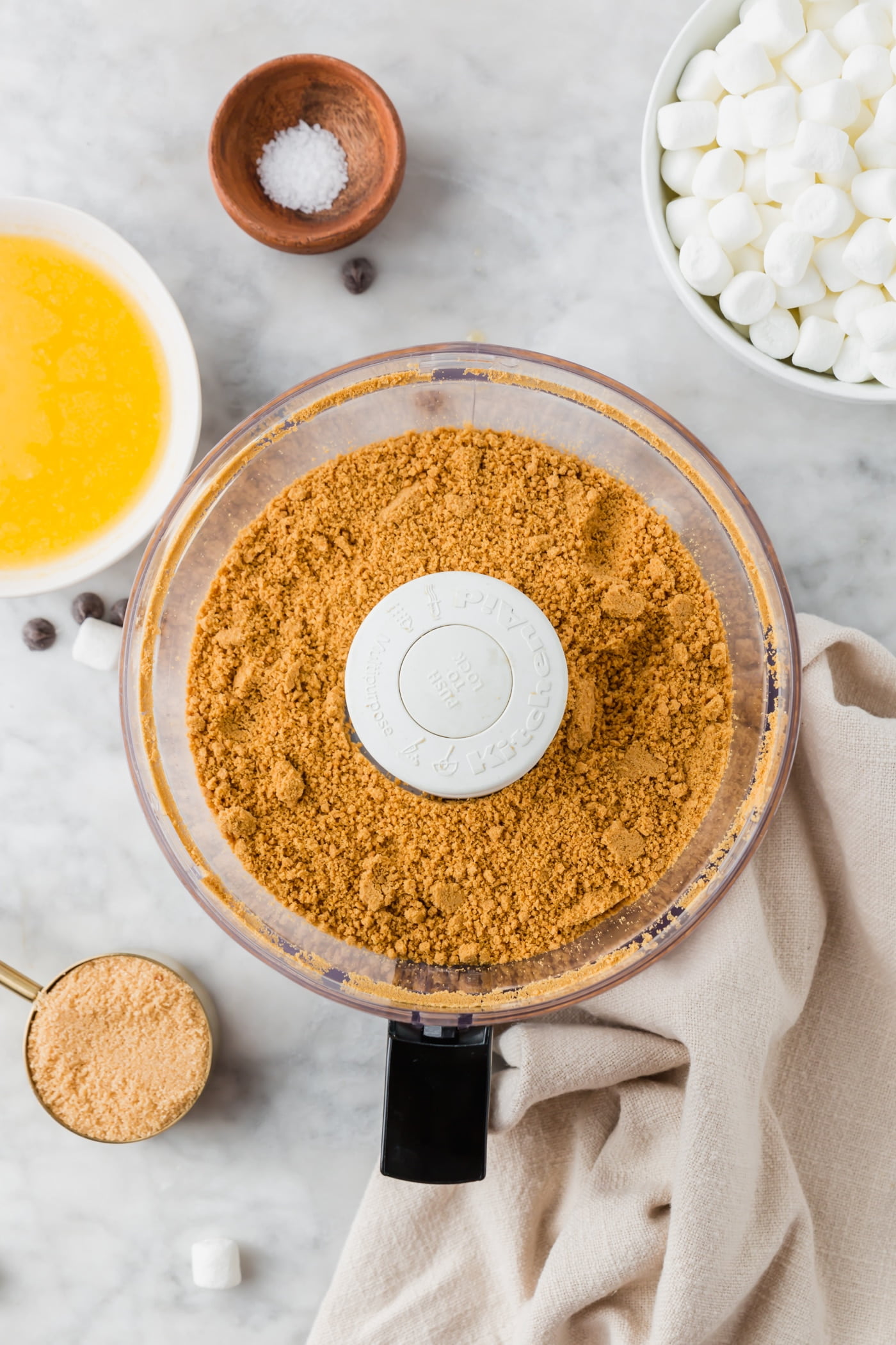 A food processor with finely ground graham crackers in it.