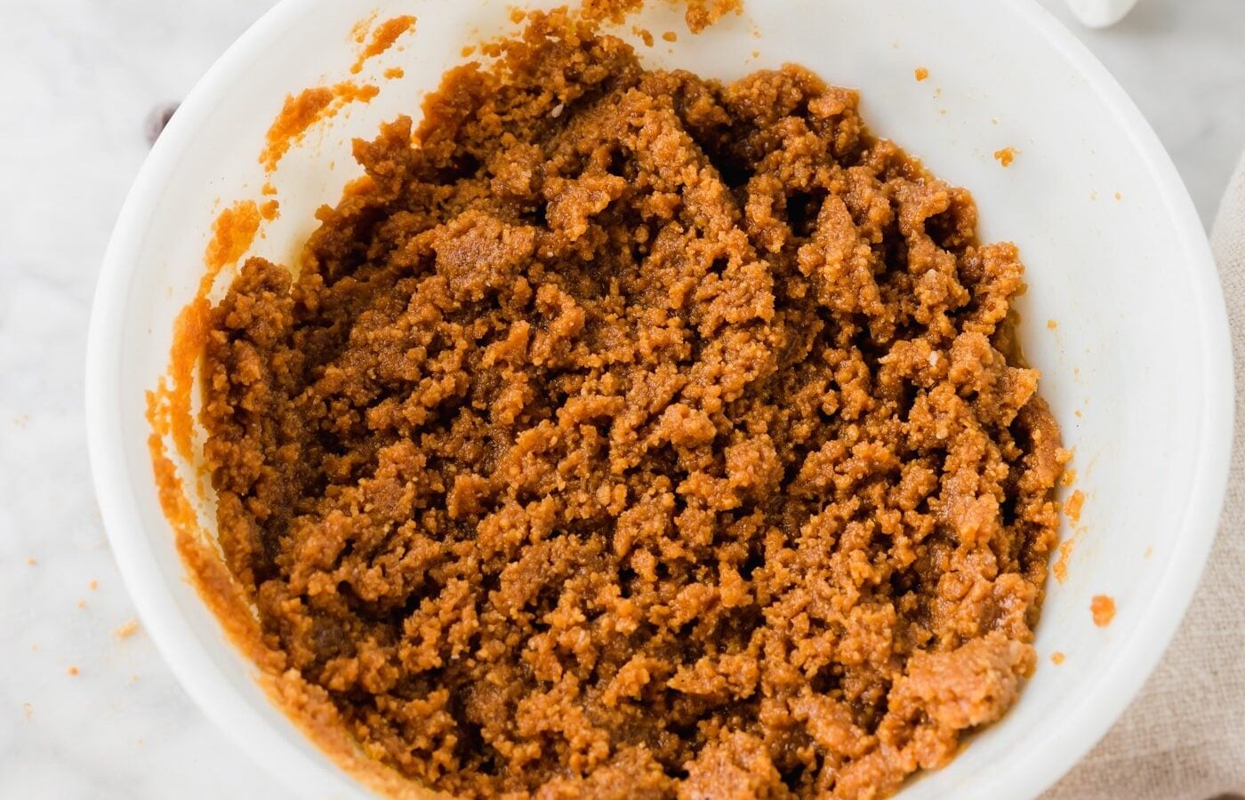 A bowl with graham cracker crust just mixed with melted butter.