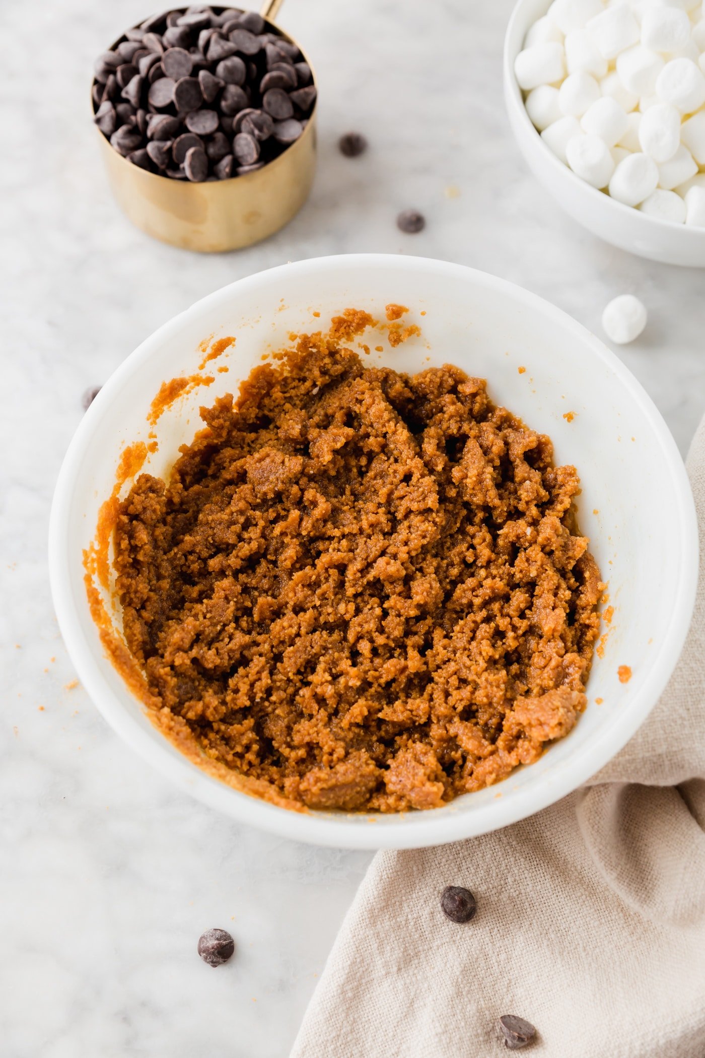 A bowl with graham cracker crust just mixed with melted butter.