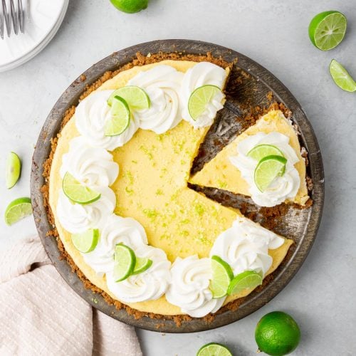 An overhead photo of a key lime pie with a slice cut out of it in a pie tin.