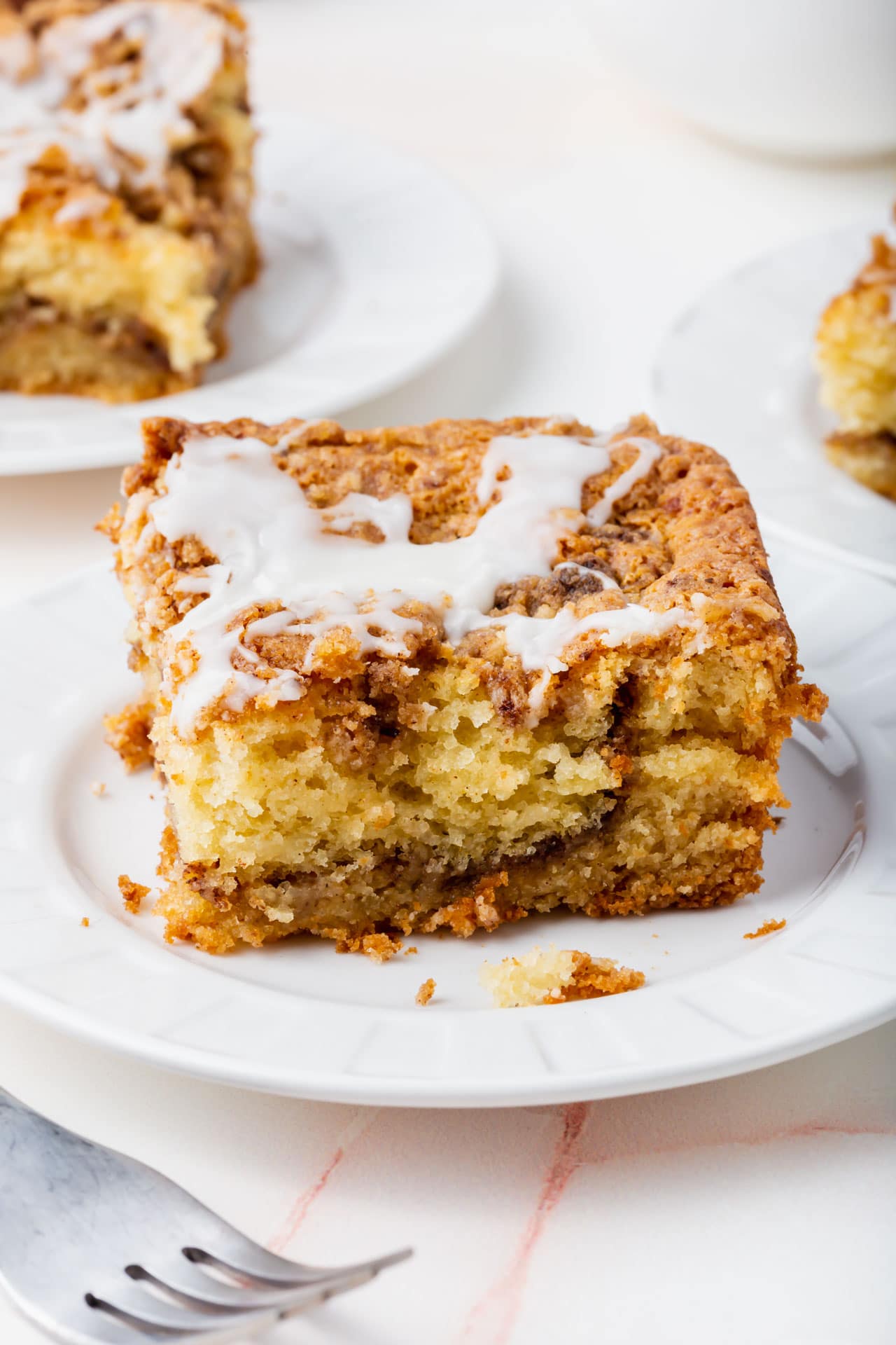 A slice of gluten-free cinnamon coffee cake on a small plate. 