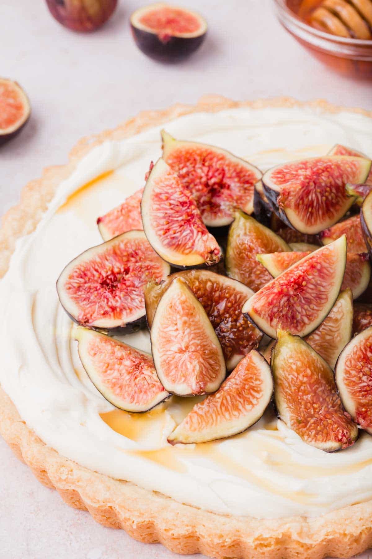 Full tart with buttery shortbread crust, mascarpone filling, topped with fresh figs.