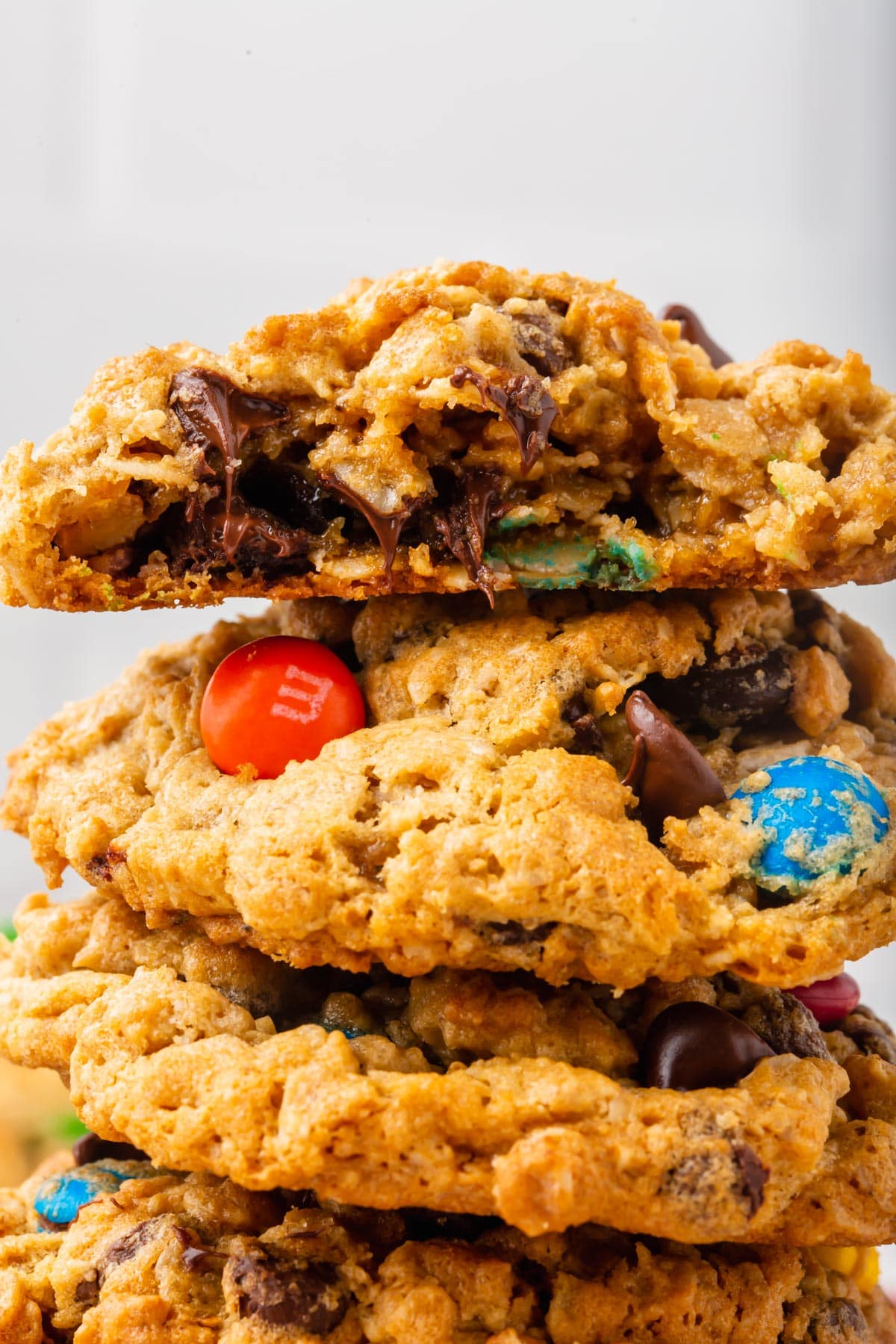 Stack of monster cookies with top cookie broken in half.
