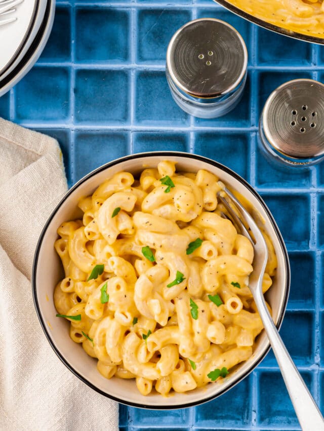 A bowl of gluten-free mac and cheese topped with fresh parsley.