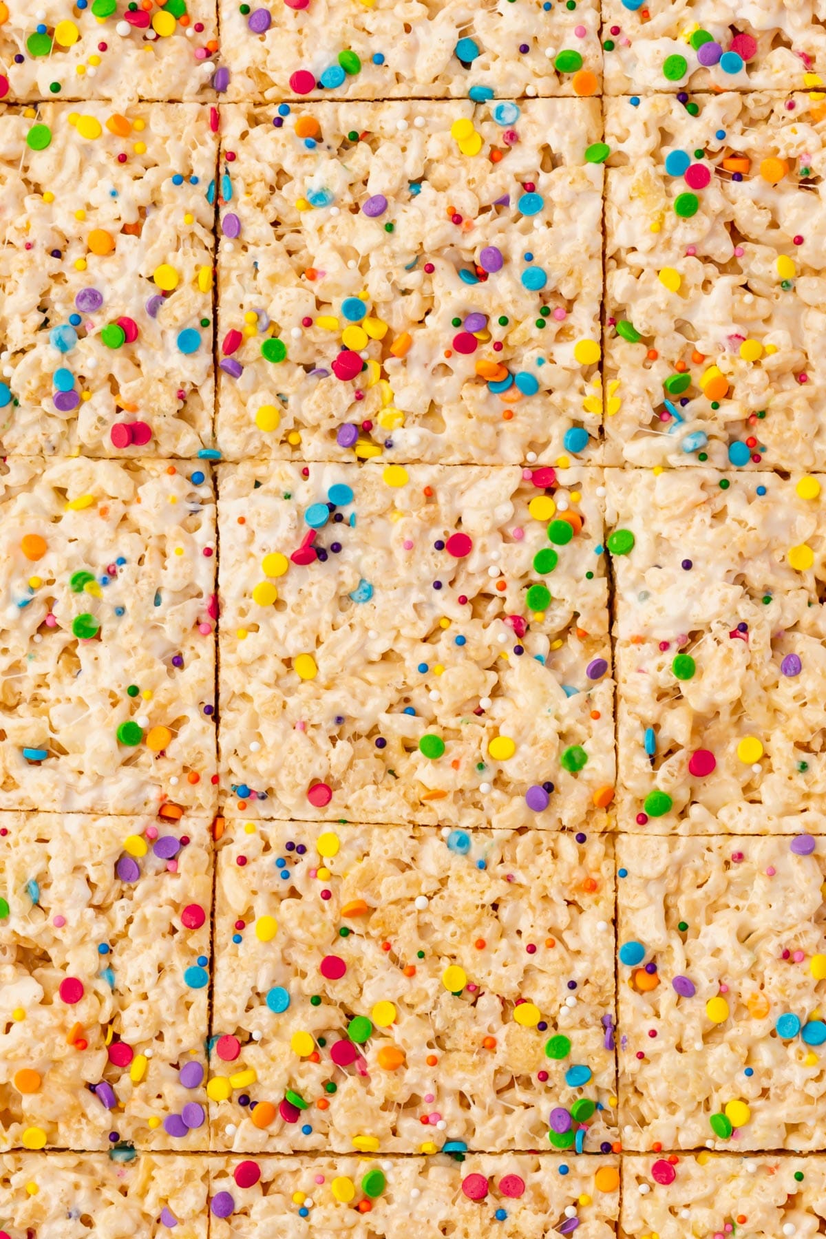 A tray of gluten-free rice krispies treats topped with colorful sprinkles.