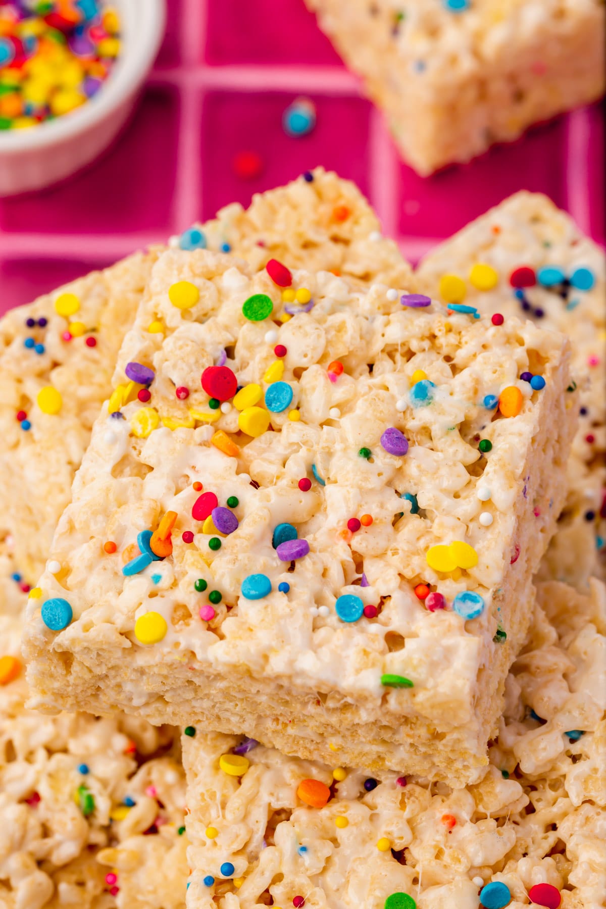 A pile of gluten-free rice krispies treats topped with colorful sprinkles.