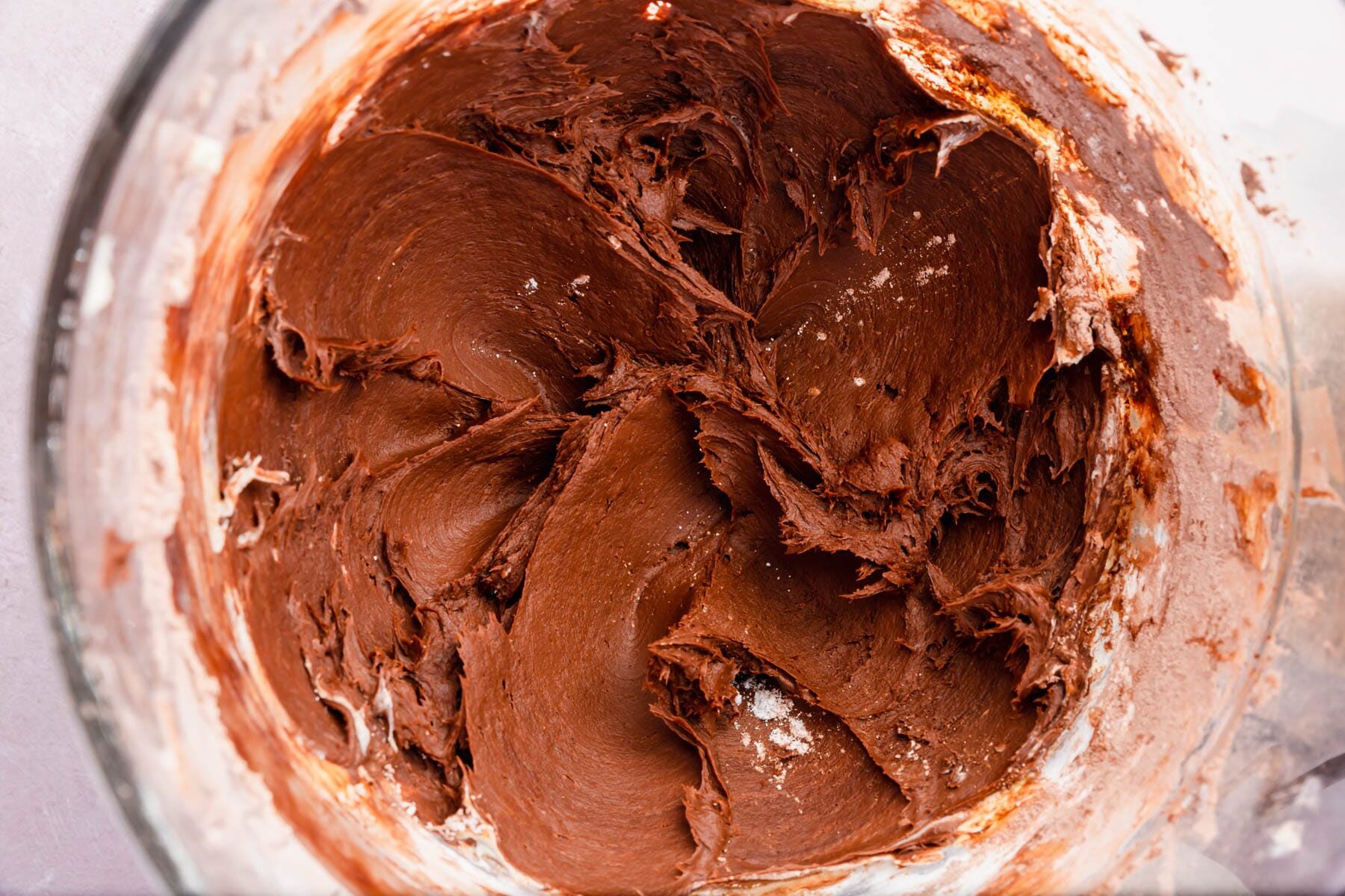 A bowl of chocolate cream cheese frosting.