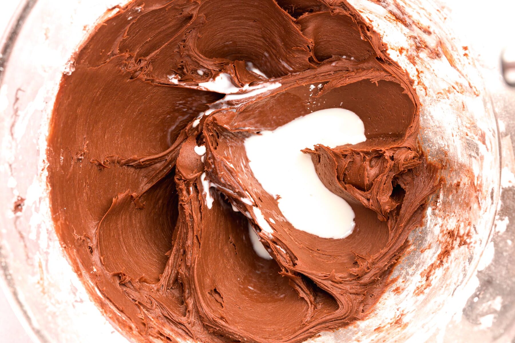 Milk poured into chocolate cream cheese frosting.