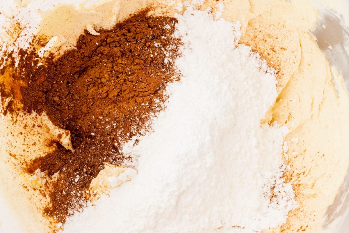 Creamed butter with cocoa powder and powdered sugar in a bowl.