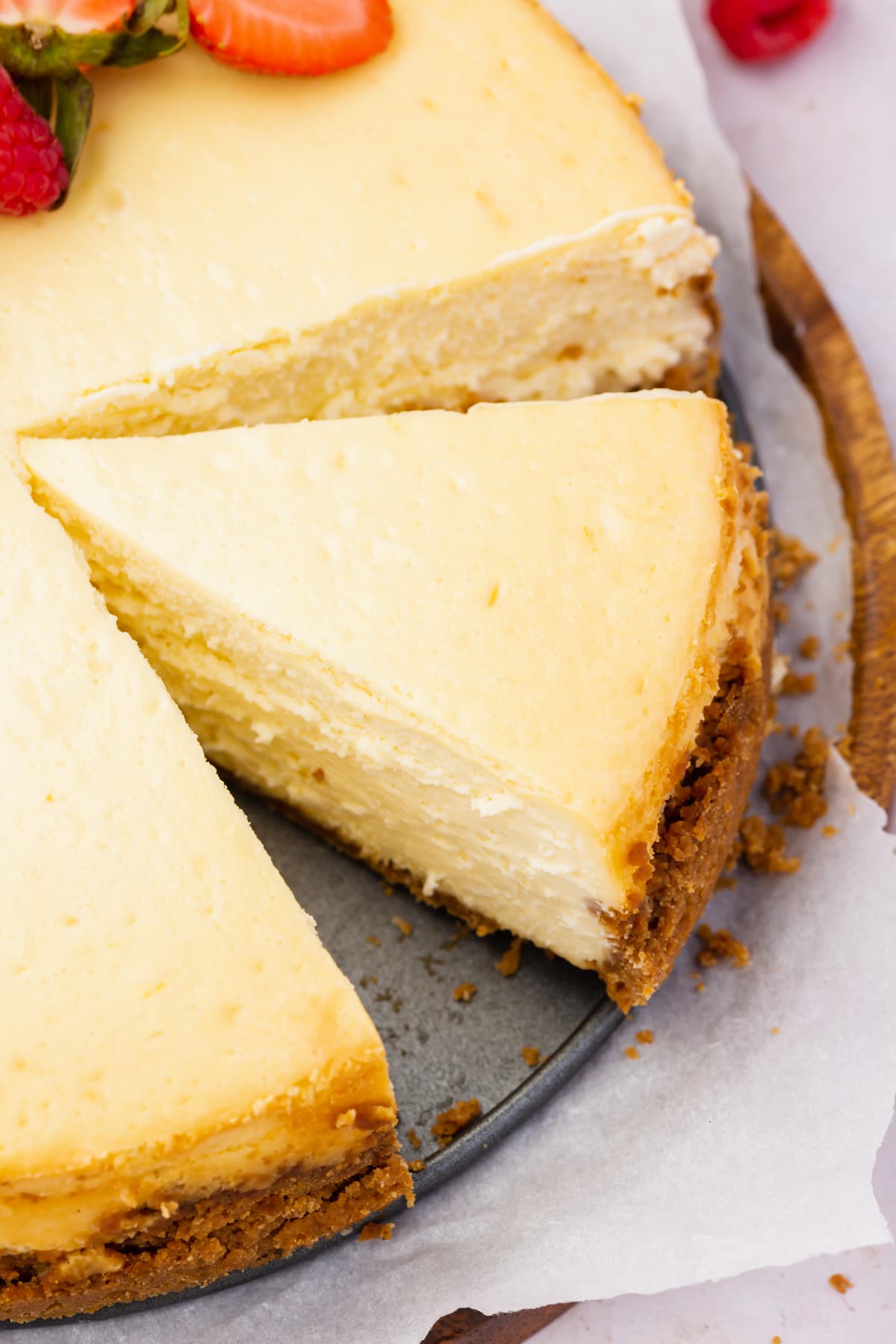 A close up of a slice of gluten-free cheesecake with a graham cracker crust.