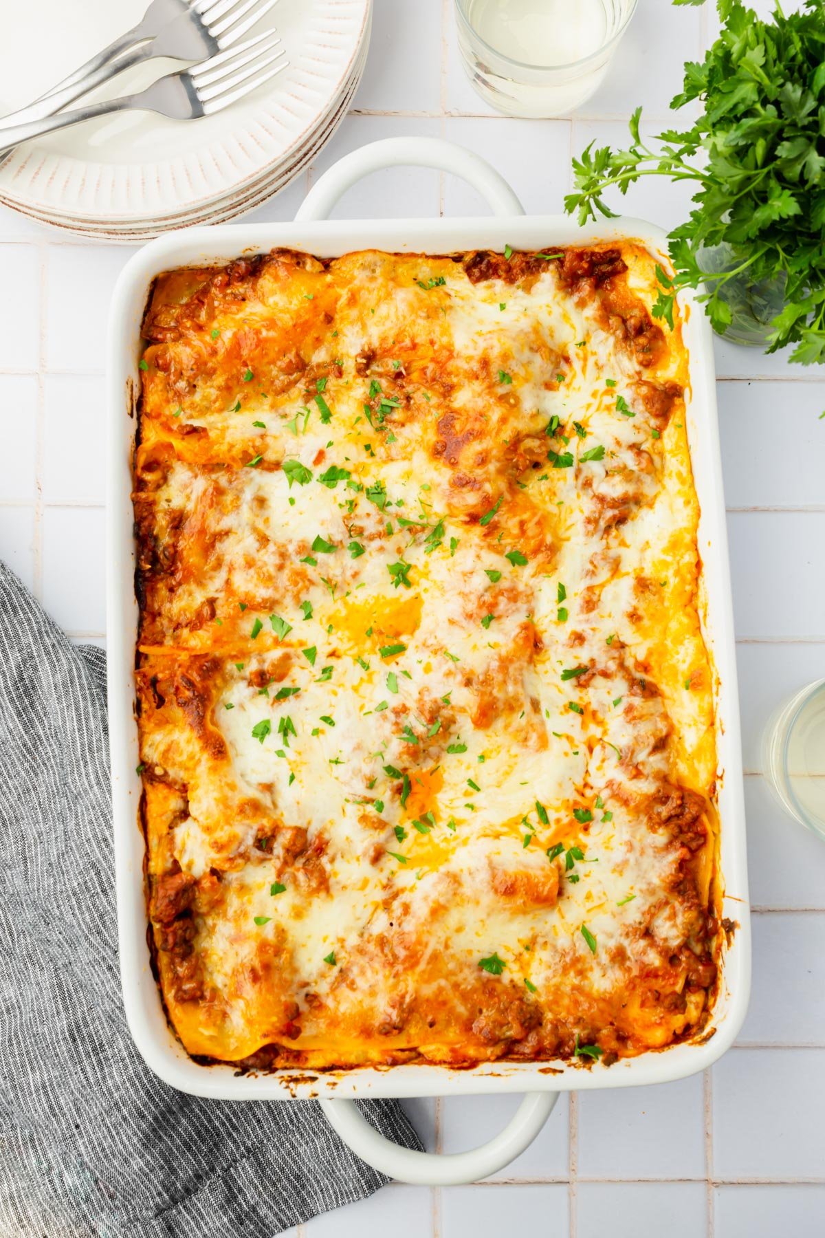A 13x19 pan of gluten-free beef lasagna topped with fresh parsley.