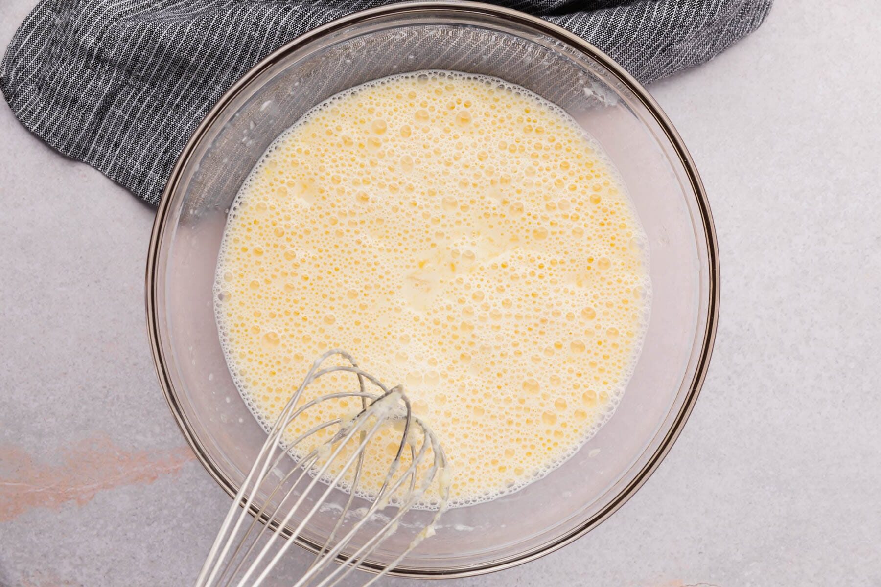 Gluten-free pancake batter with a whisk in a mixing bowl.