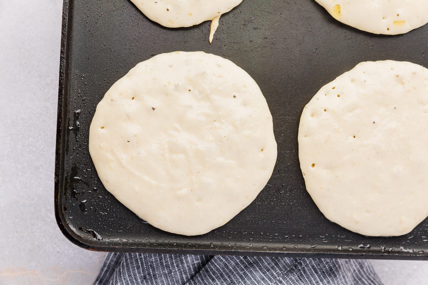 Gluten-free pancake batter being cooked on a non-stick griddle.