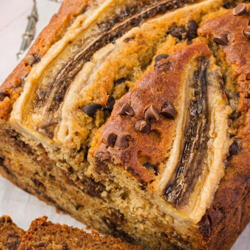 A loaf of gluten-free banana bread with chocolate chips sliced in half.