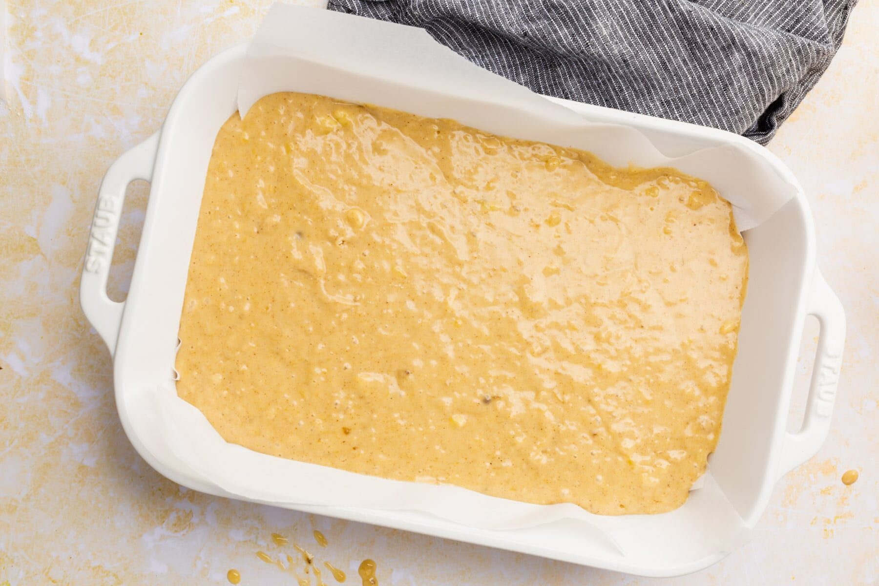 Gluten-free banana cake batter in a white baking dish.