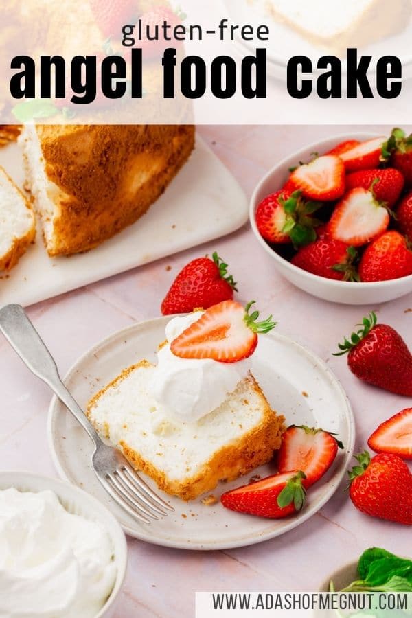 A slice of angel food cake on a plate topped with whipped cream and strawberries with a fork.